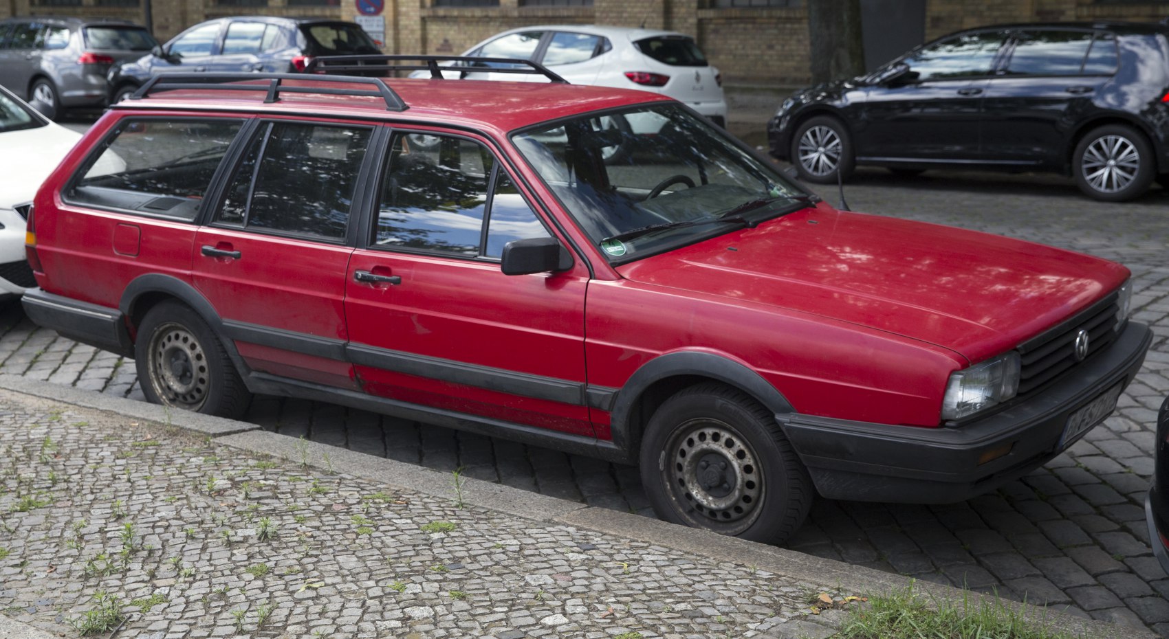Red station wagon with roof rails and black fender flares