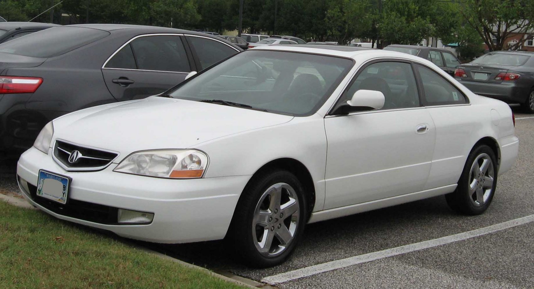 White coupe front-side view with distinctive grille and alloy wheels