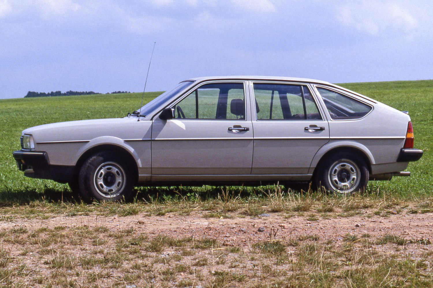 Side profile of a four-door hatchback with antenna and steel wheels