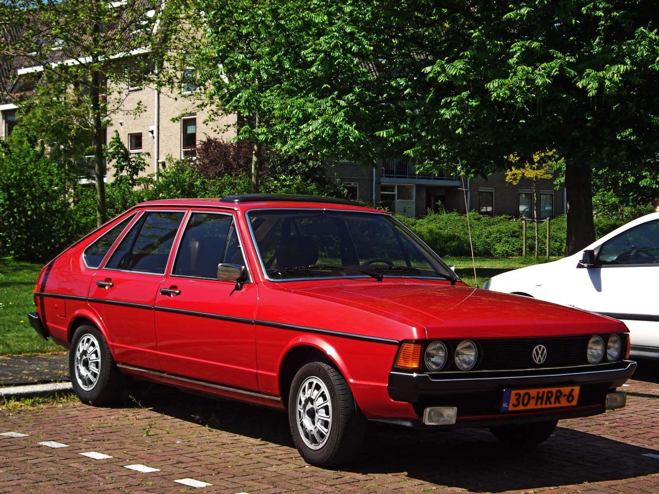 Red vintage hatchback with double round headlights and alloy wheels
