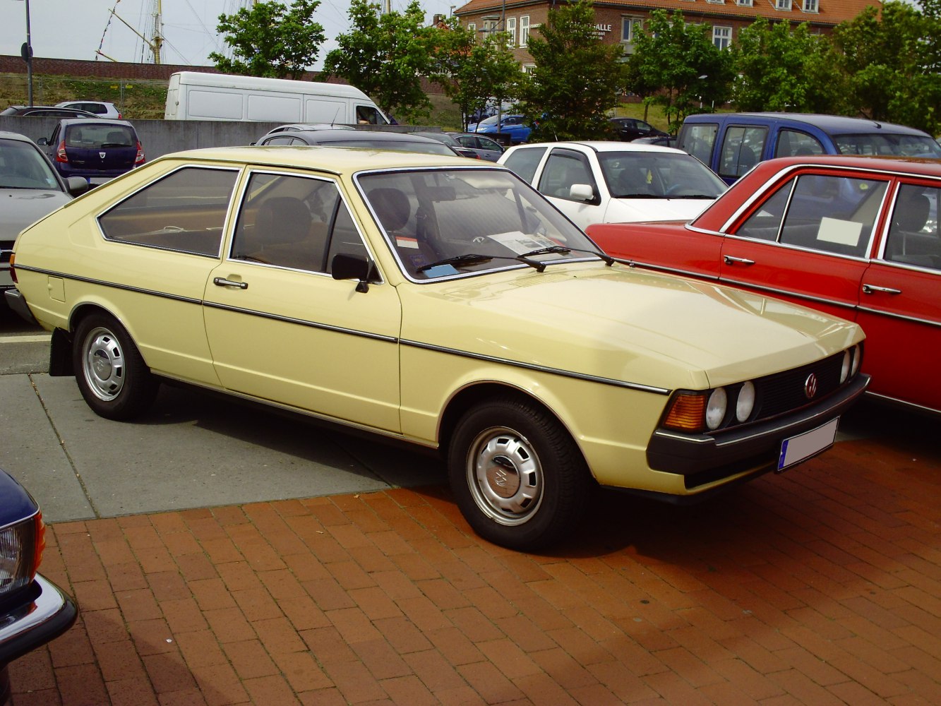 Two-door hatchback with quad headlights and steel wheels