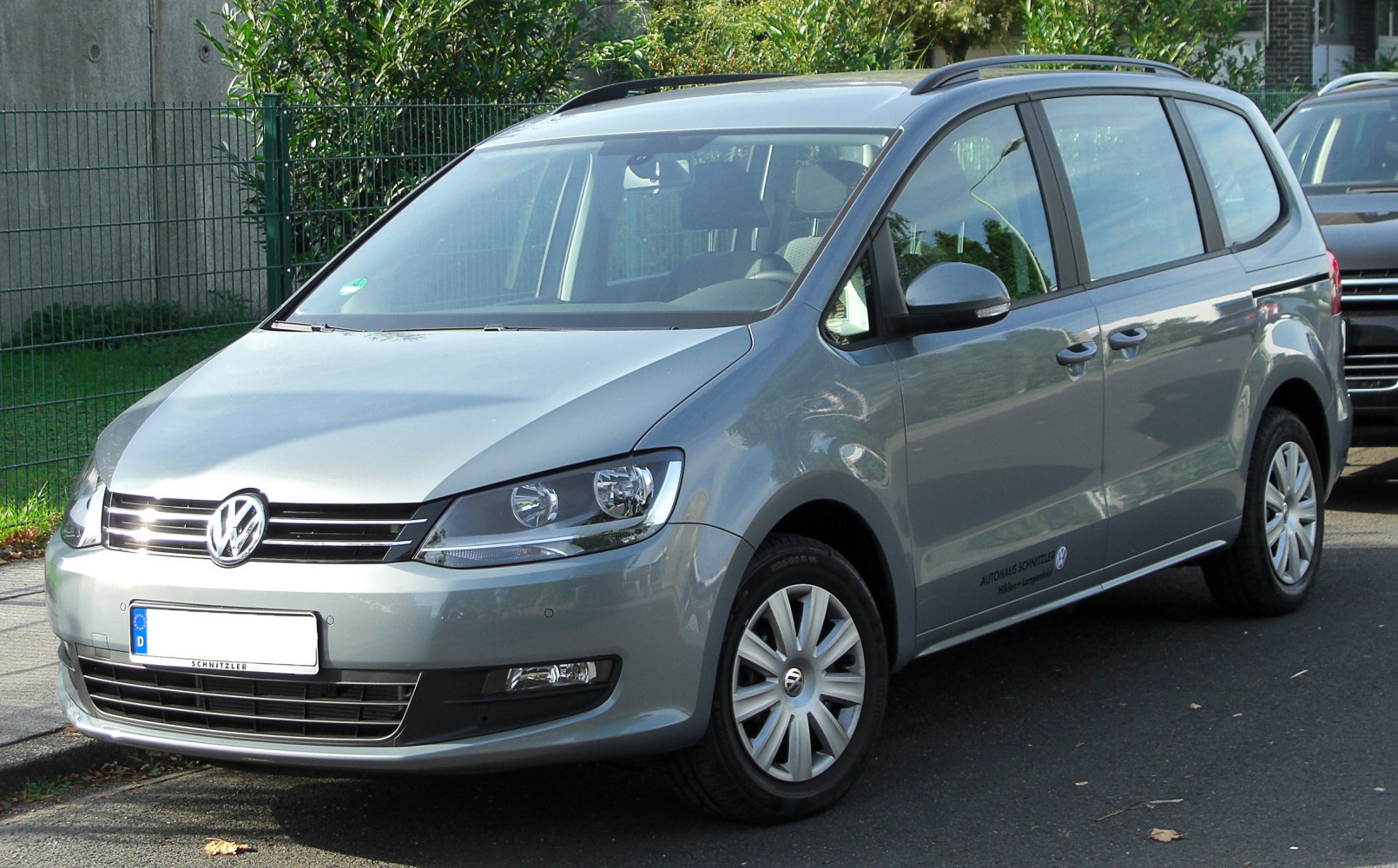 Front and side view of a silver MPV with distinct headlight and body shape