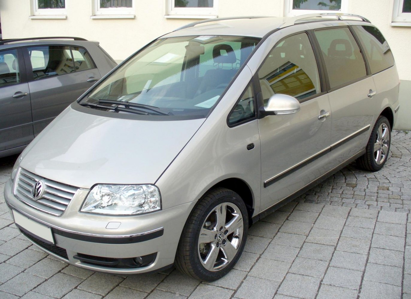 2004 minivan front side with alloy wheels and large headlights