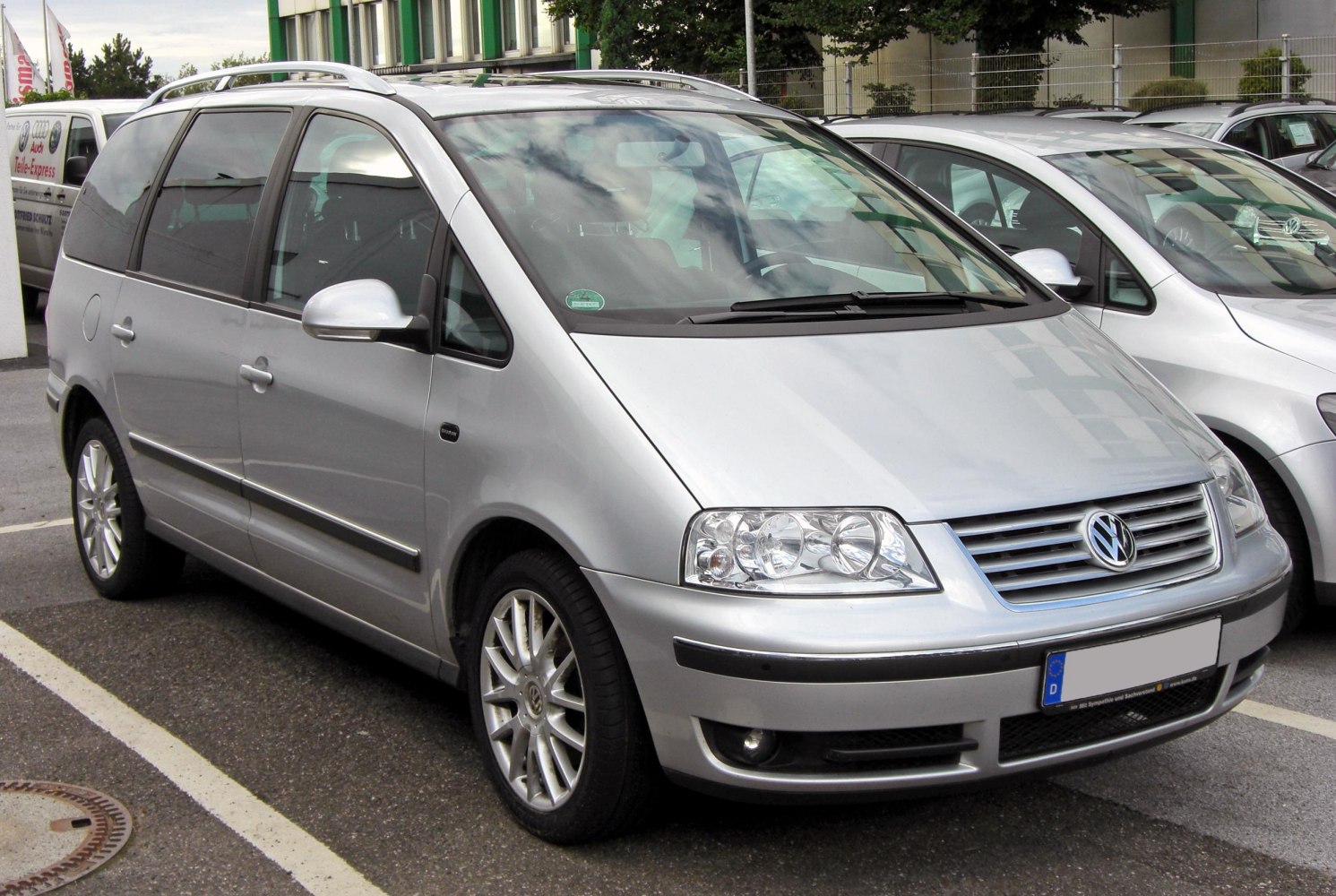 Silver MPV with alloy wheels and roof rails front side view