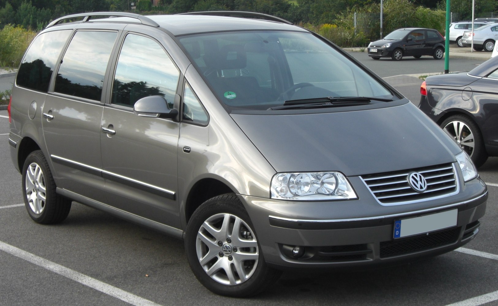 Front and side view of a minivan with alloy wheels and roof rails