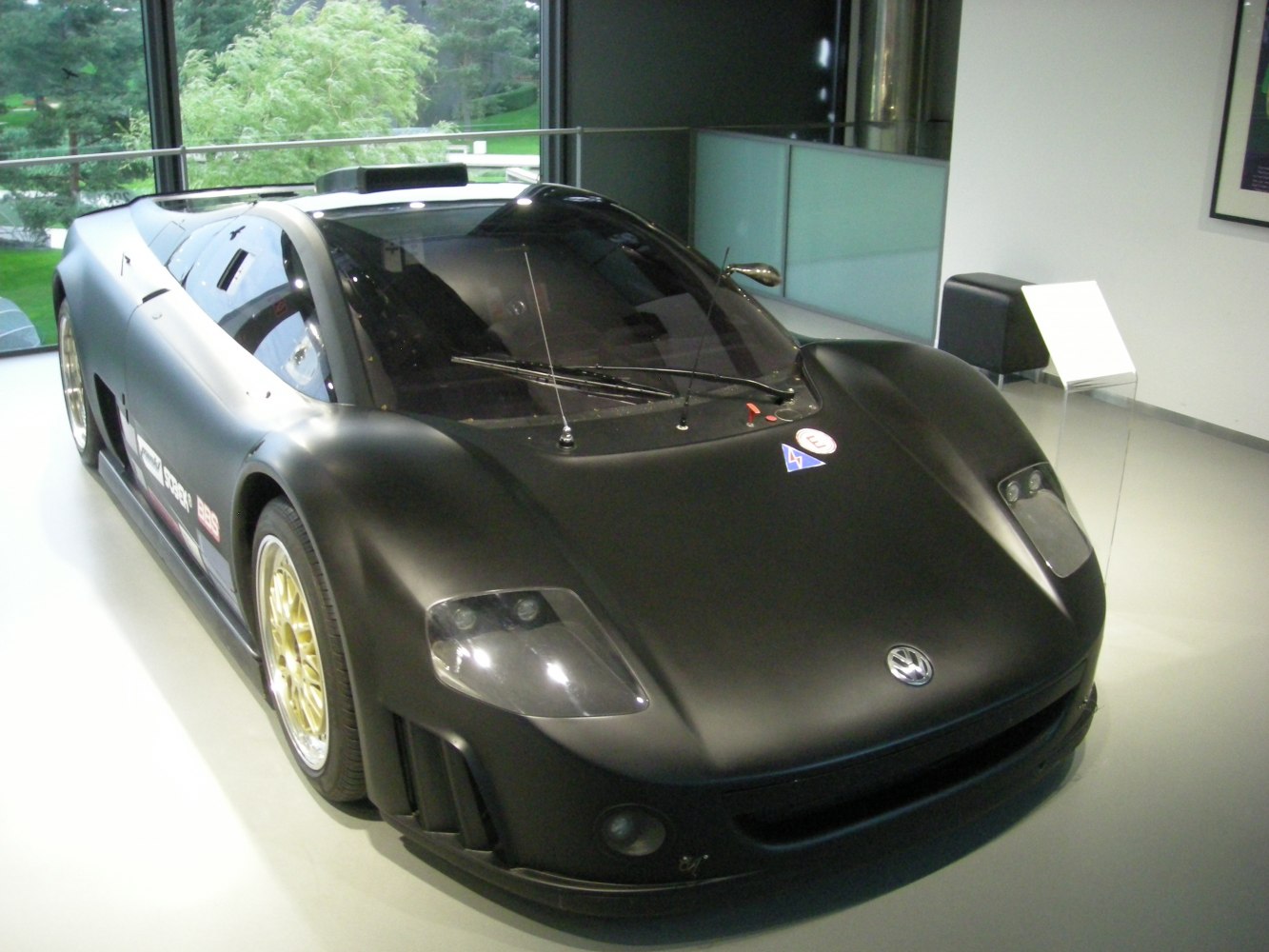 Matte black racing bodywork with aerodynamic front and gold rims