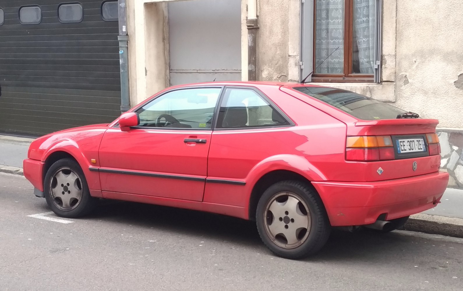 Red classic coupe with distinctive rear spoiler and alloy wheels