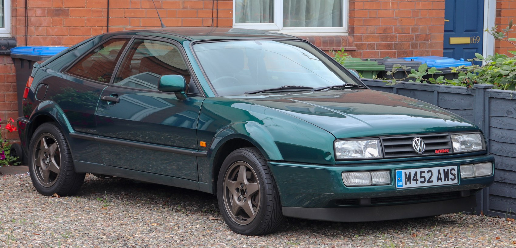 Front side view of a sporty two-door coupe with distinctive headlights and alloy wheels