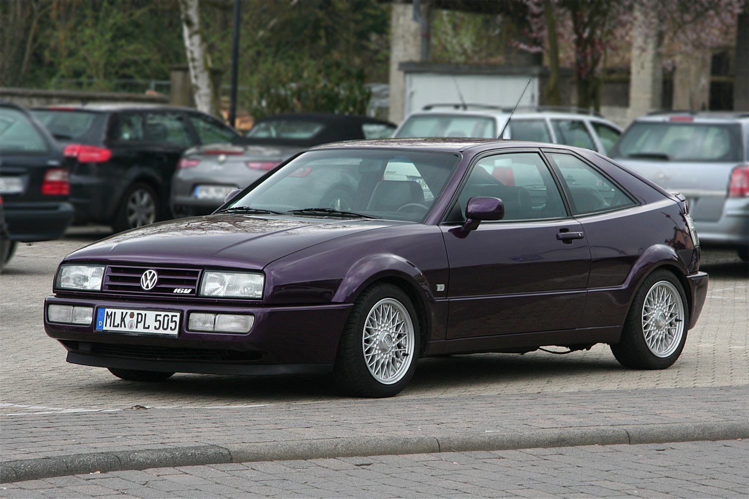 Side-front view of a compact hatchback with mesh alloy wheels