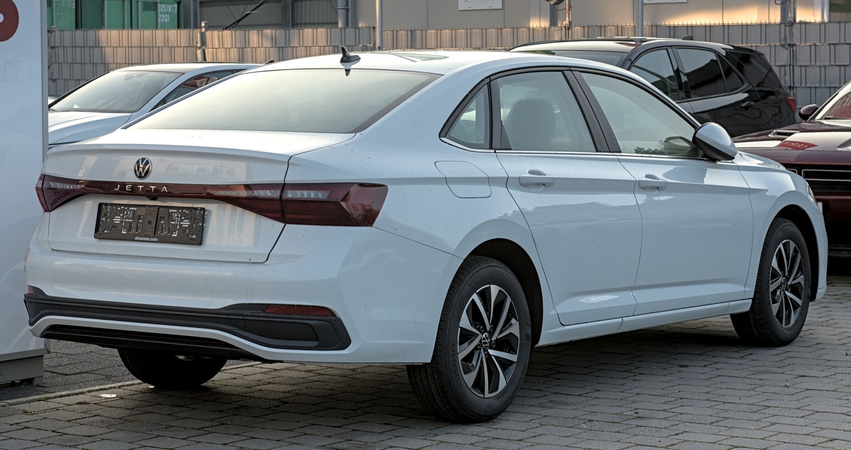 Rear and side view of a modern four-door sedan featuring sleek taillights and alloy wheels