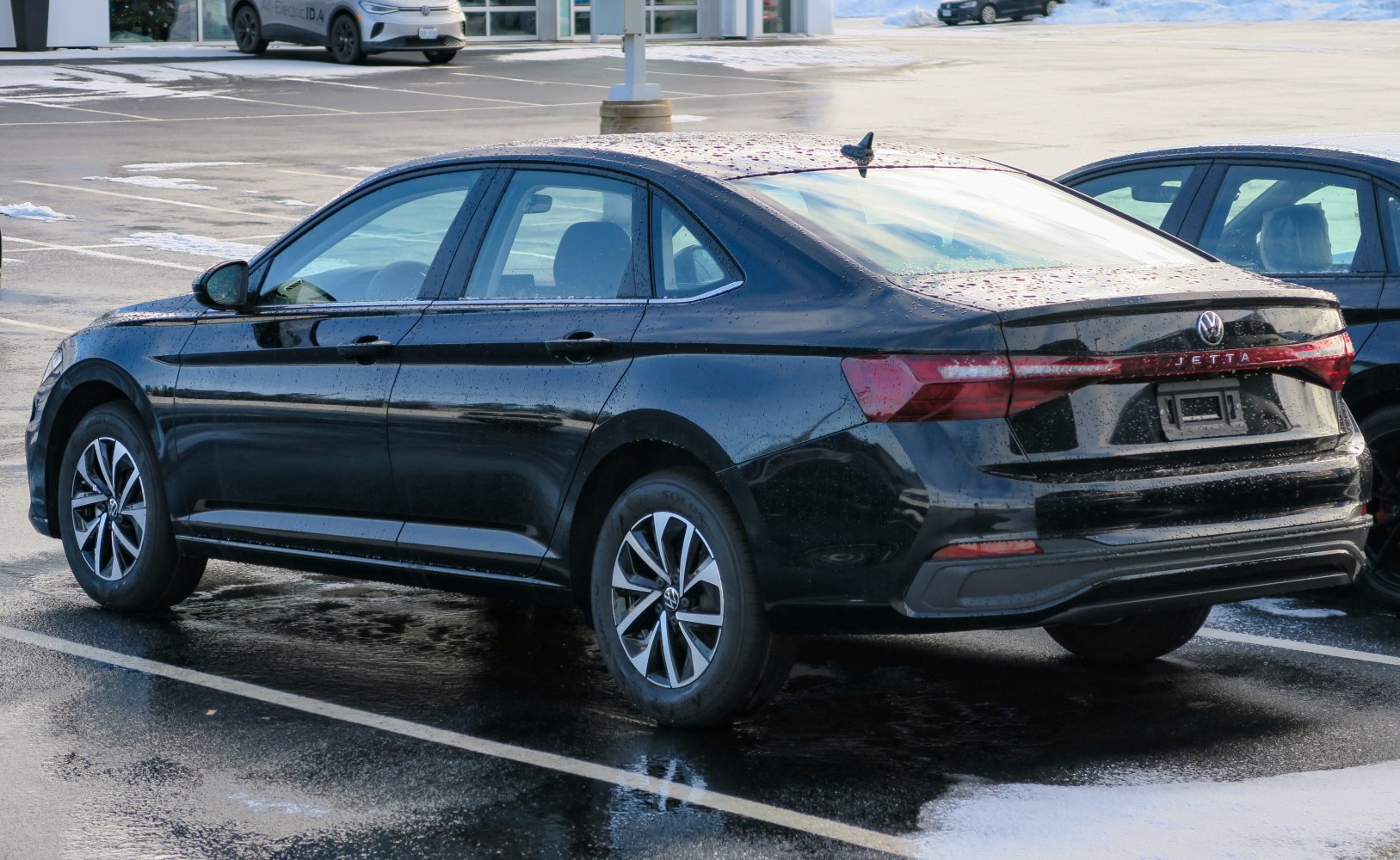Rear and side view of a black sedan with sleek taillights and aerodynamic profile