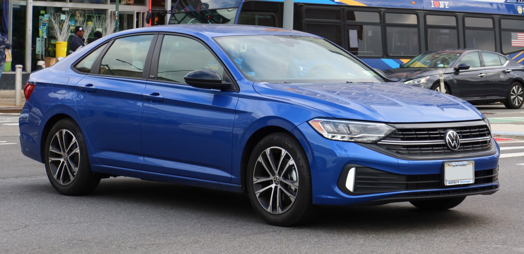 Front side view of blue sedan with sleek headlights and alloy wheels