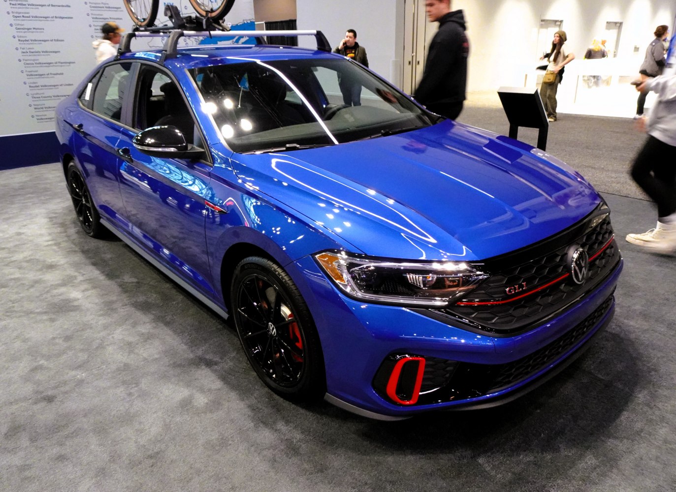 Front view of blue sporty sedan with roof rack and black wheels