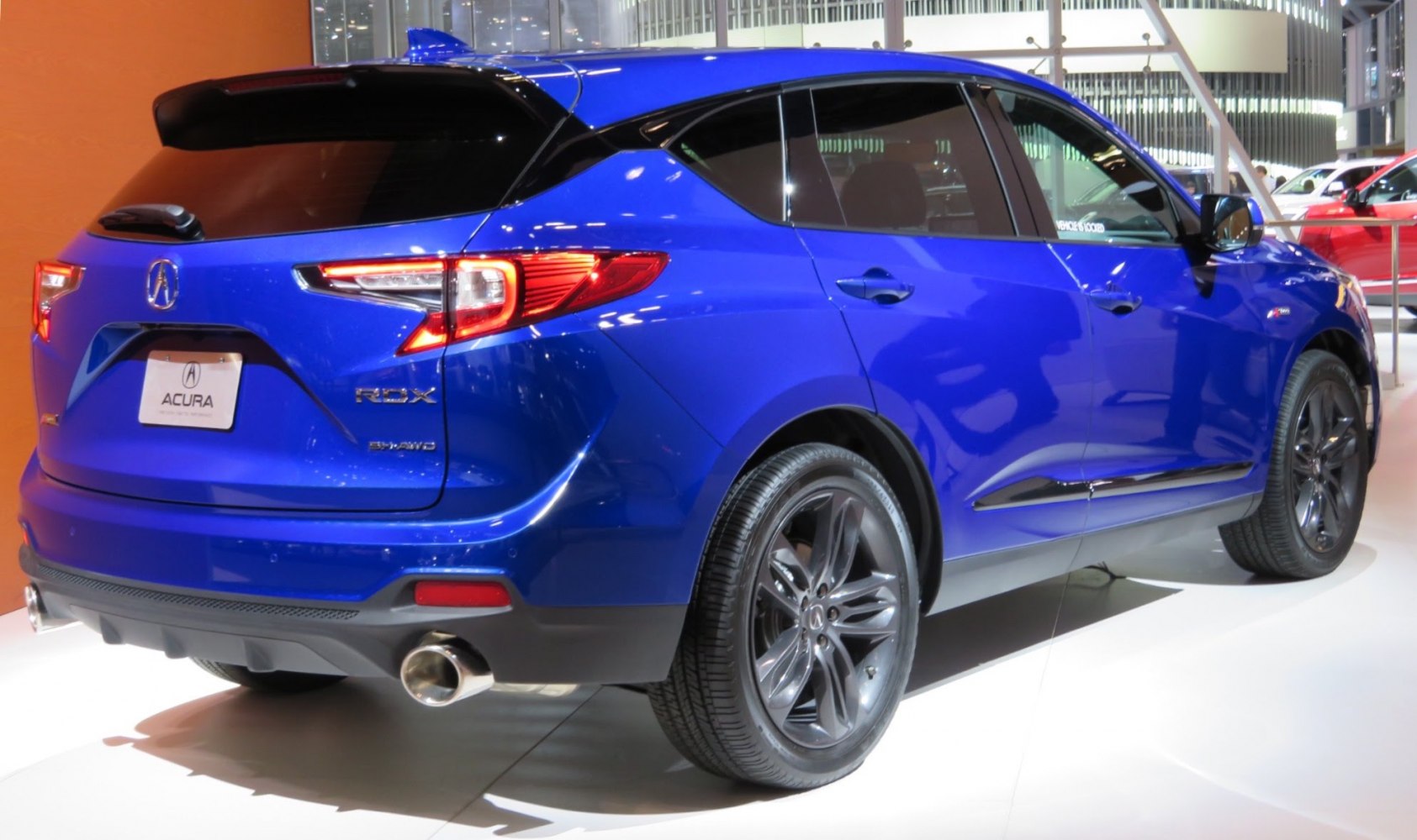 Rear side profile of a modern SUV with dual exhausts and dark alloy wheels.