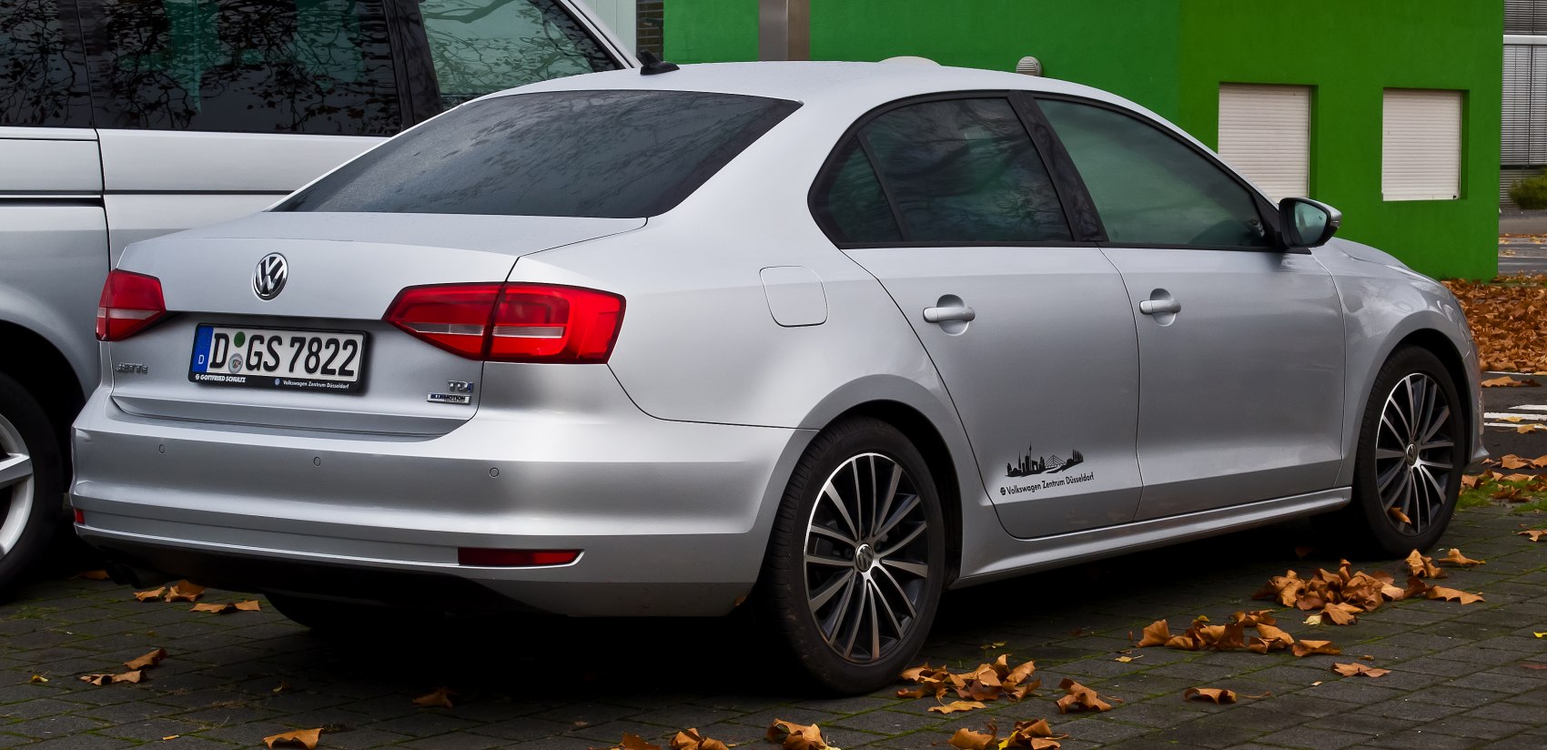 Rear view of a silver sedan with clear taillights and alloy wheels