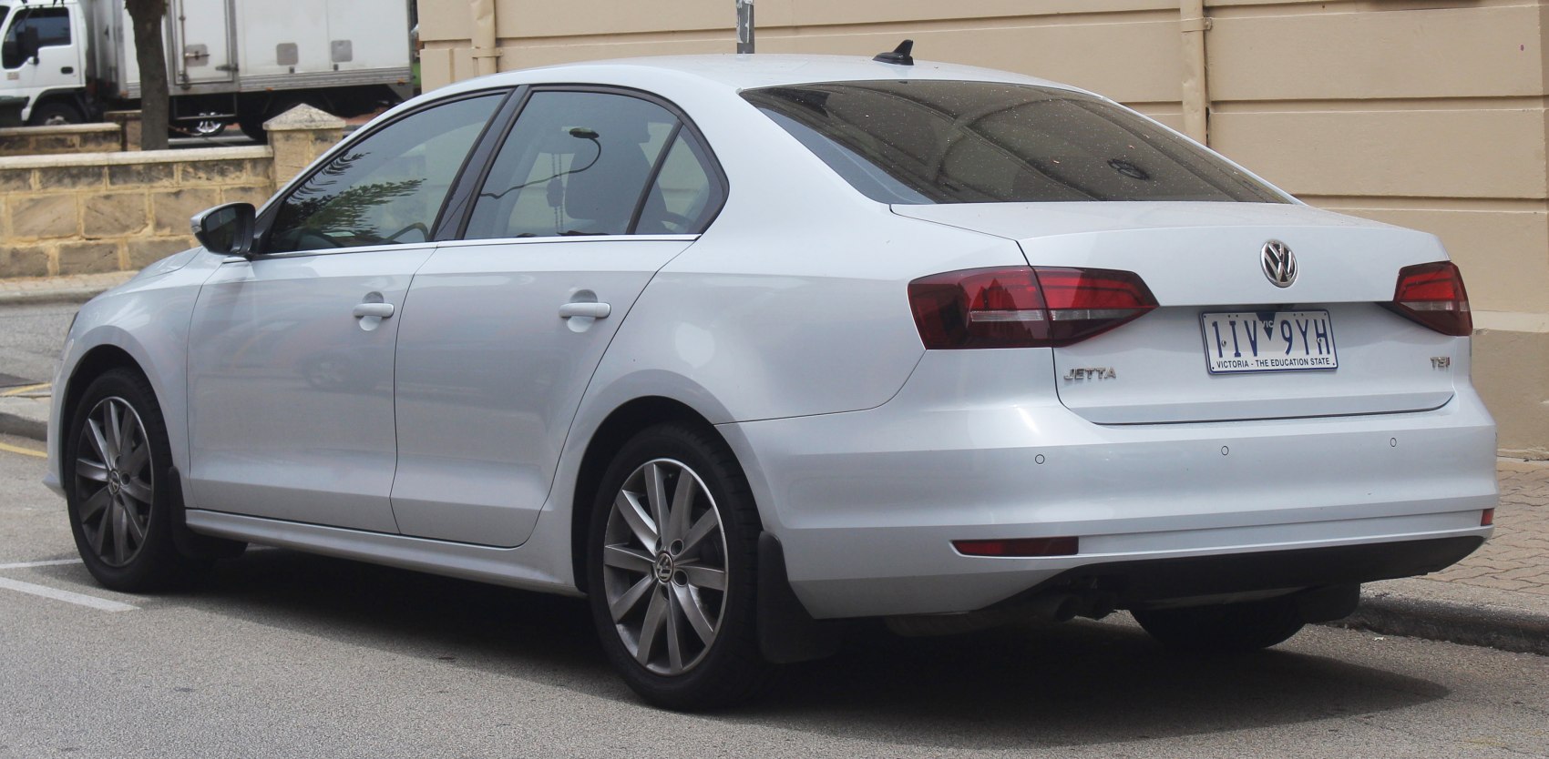 Rear and side view of sedan with alloy wheels and tinted windows