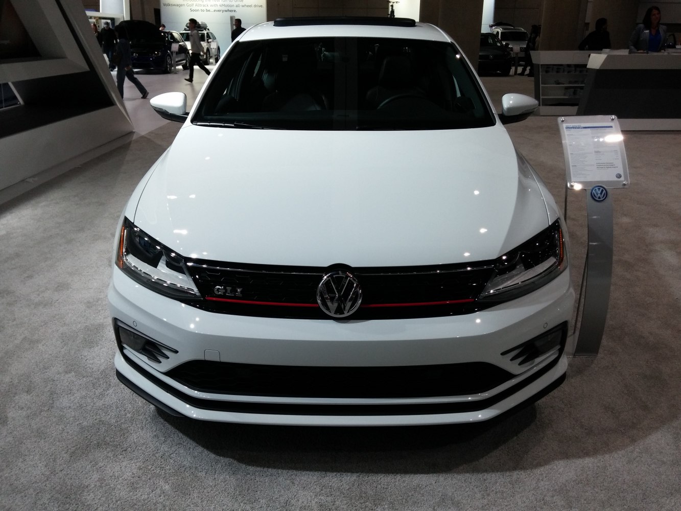 Front view with black grille, red stripe, GLI badge, modern headlights