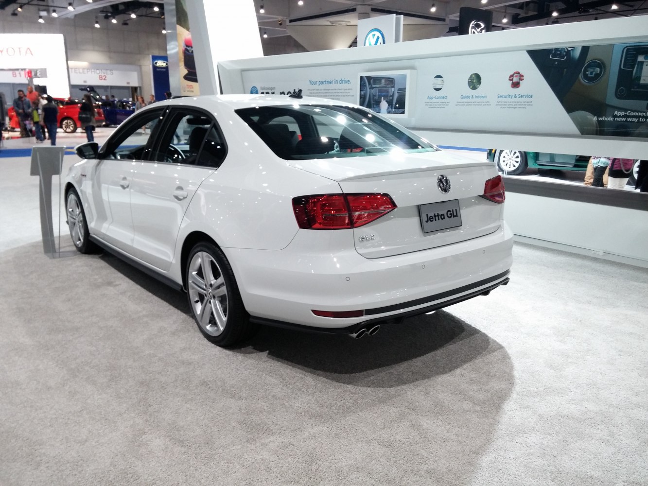 White four-door sedan rear with dual exhaust and LED taillights