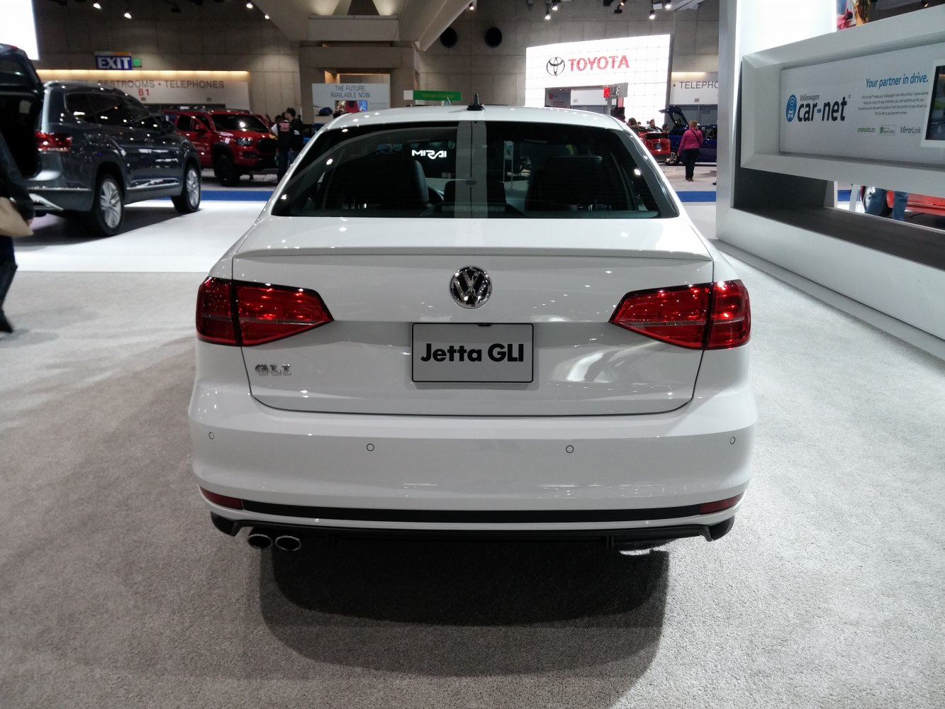 White sedan rear with dual exhaust and angular tail lights