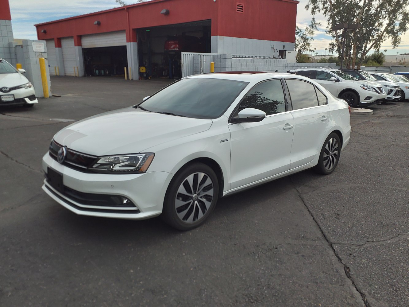 White sedan with modern headlights and alloy wheels viewed from front side