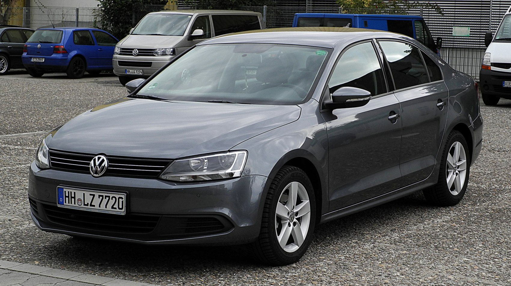 Front view of a sleek gray sedan with modern headlights and alloy wheels