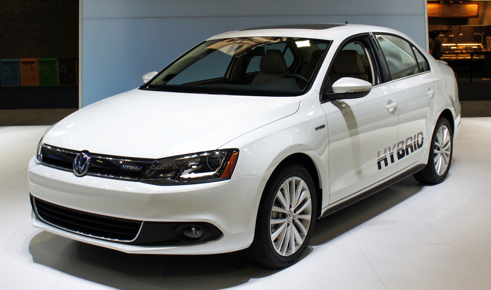 White hybrid sedan front side with aerodynamic design and alloy wheels
