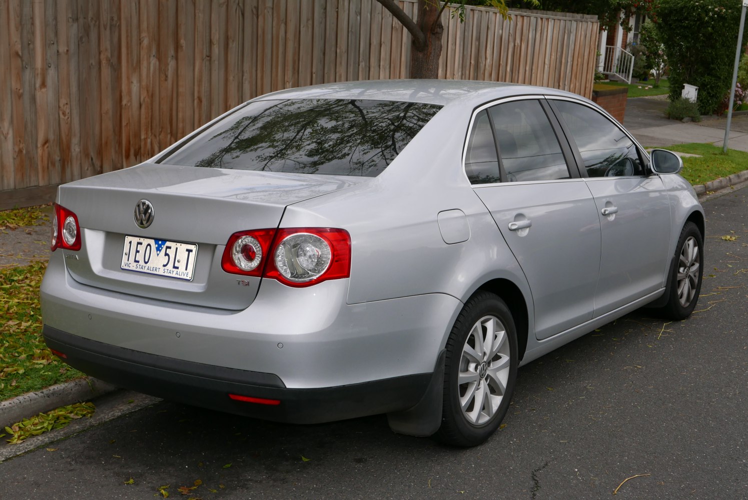 Silver sedan rear profile with round tail lights and alloy wheels