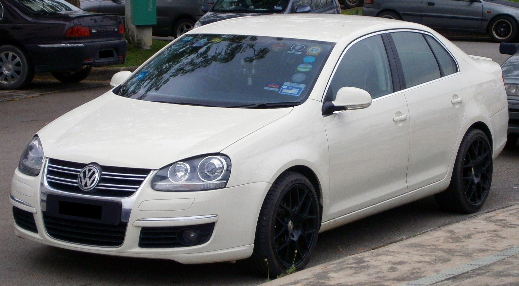 Front and side view of a sedan with prominent headlights and black wheels