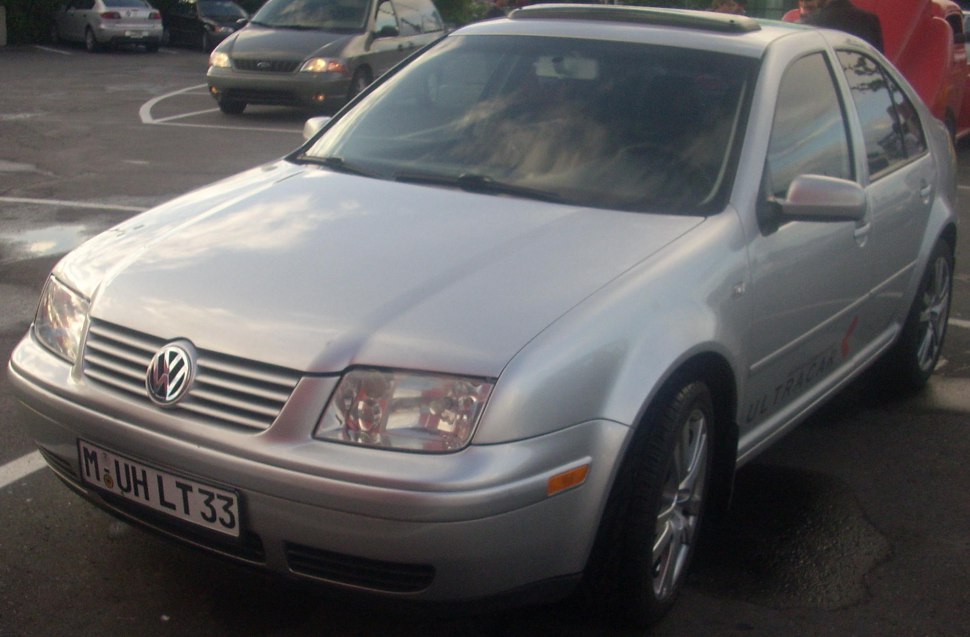 Silver sedan front view with headlights and alloy wheels