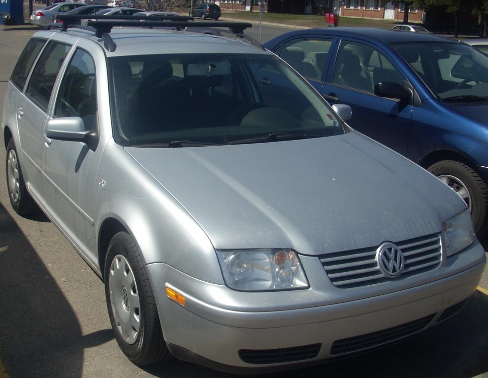 Silver station wagon with roof rack, front-side perspective.