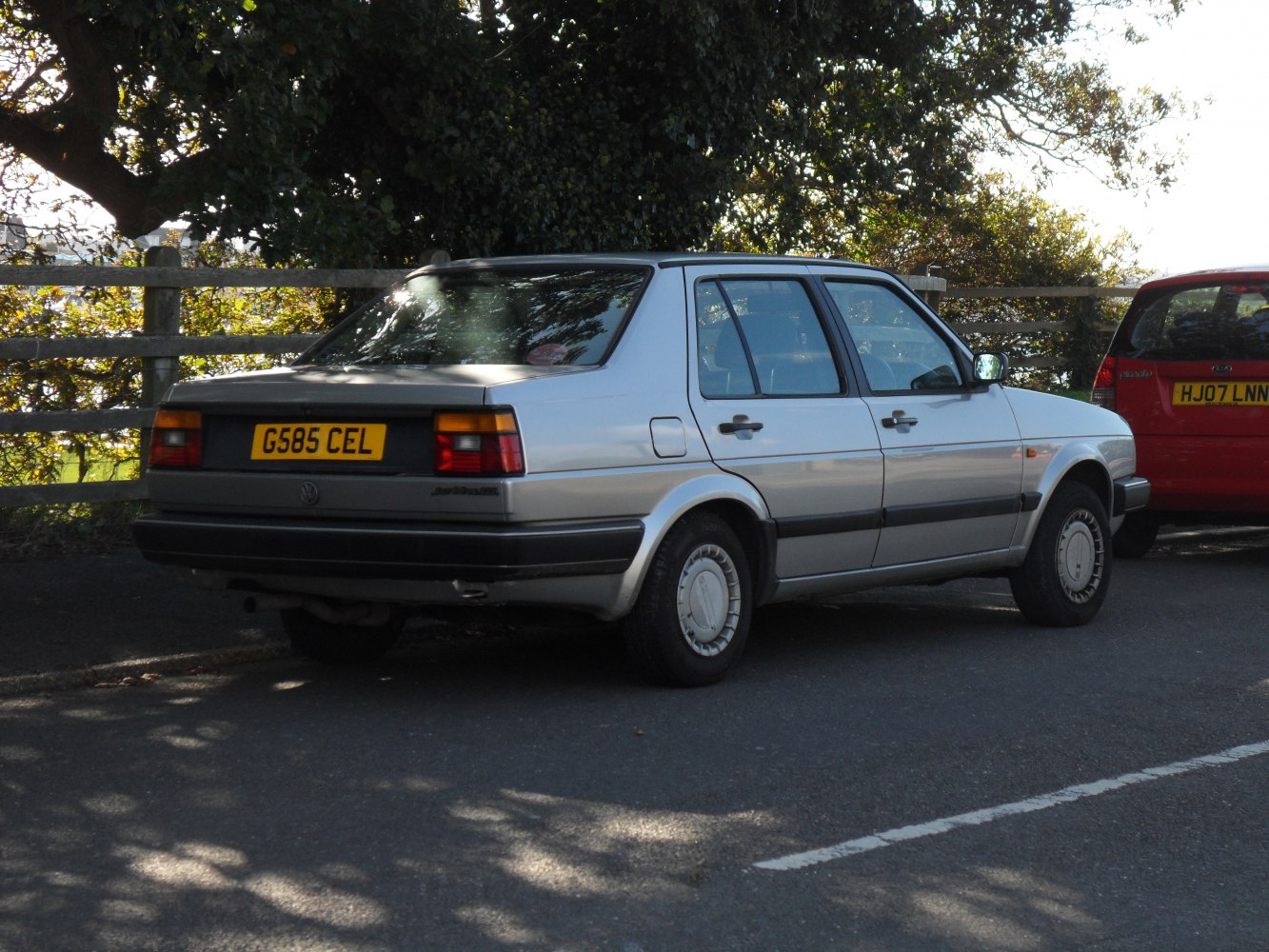Rear side view of a four-door sedan with rectangular taillights and silver paint