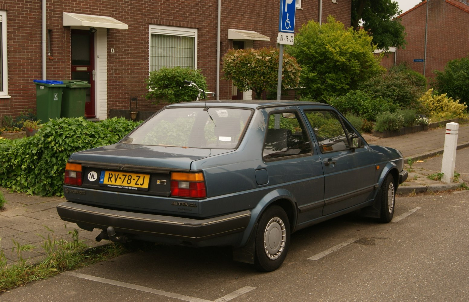 Rear view of a 1980s 2-door car with boxy shape and antenna