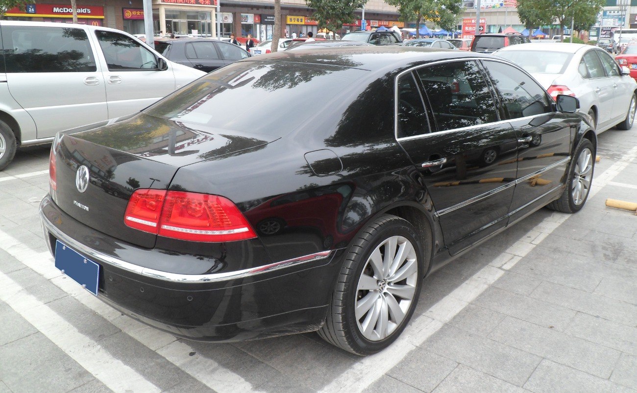 Rear and side view of large luxury sedan with chrome trim and alloy wheels
