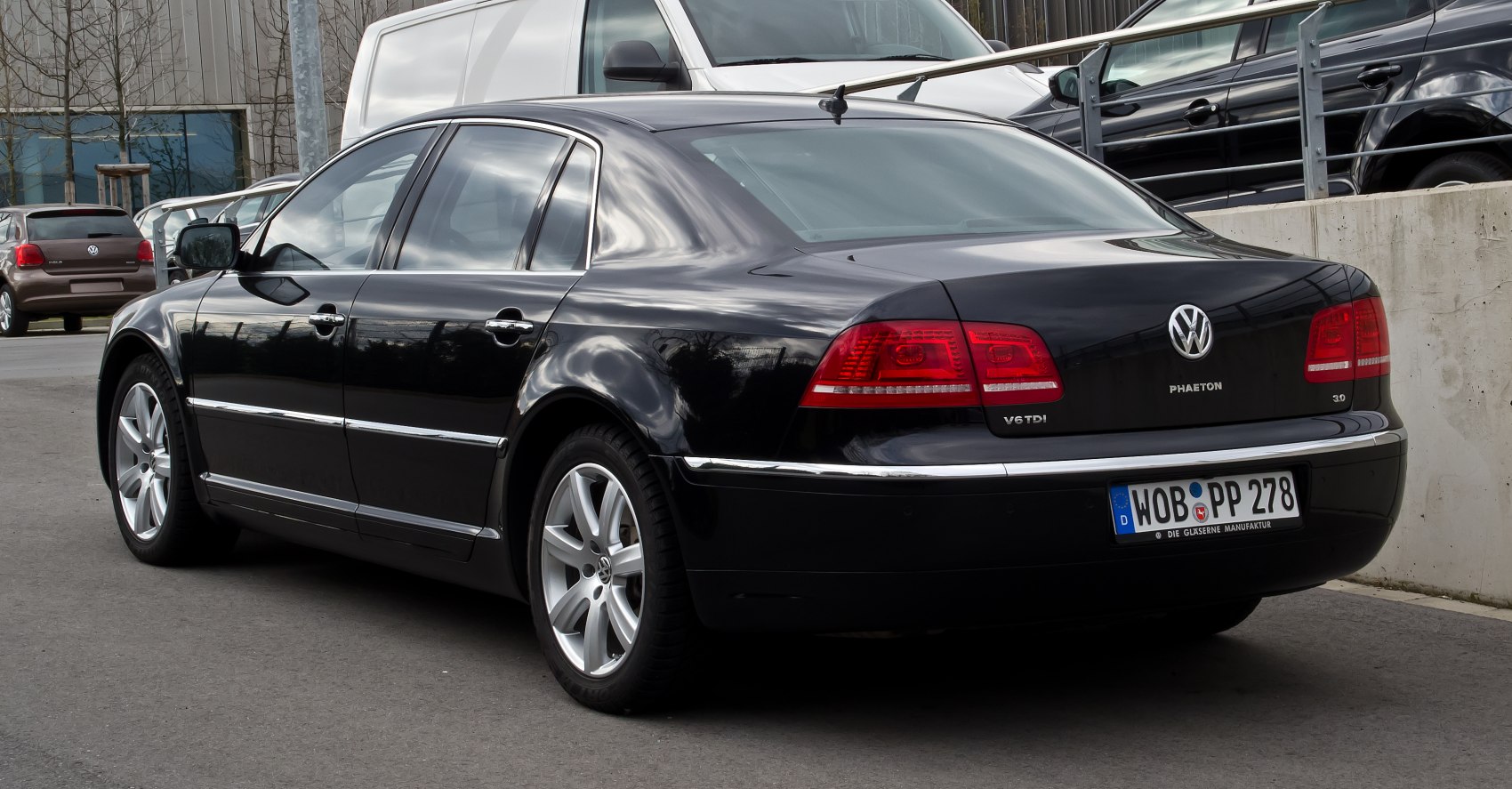 Rear view of a black sedan with distinctive taillights and chrome trim