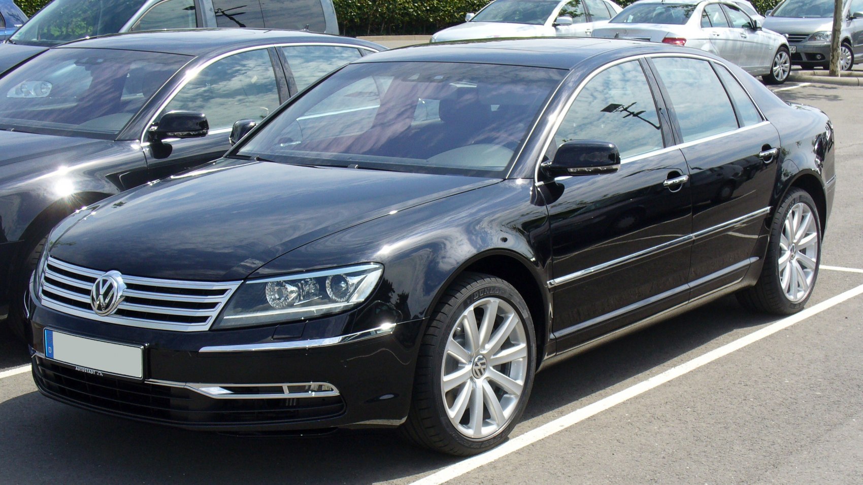 Black luxury sedan front and side view with distinctive grille and headlights