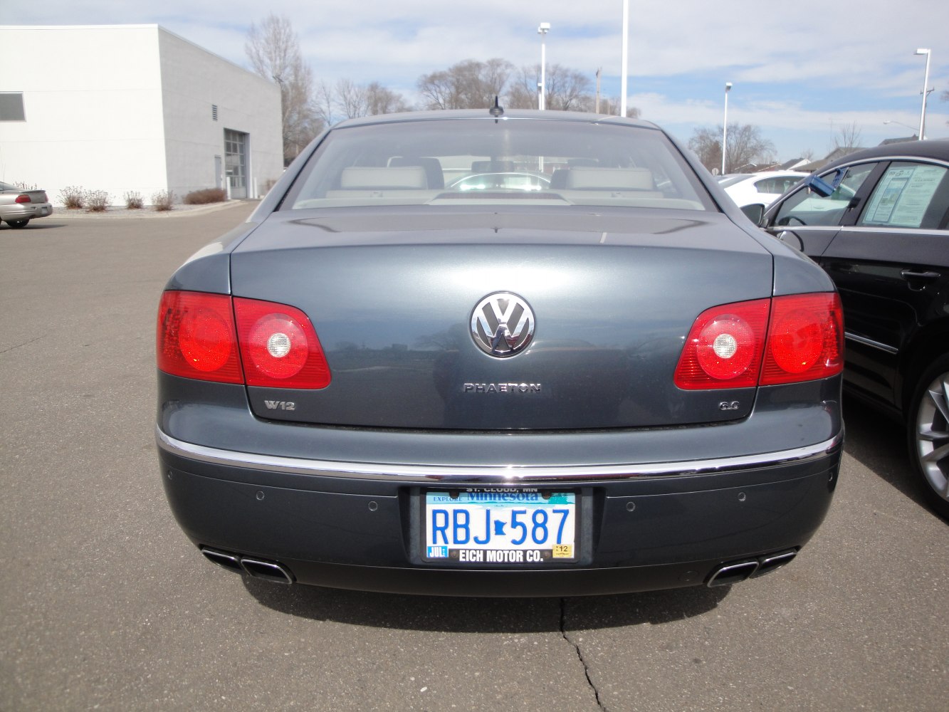 Rear view of luxury sedan with dual exhausts and red taillights