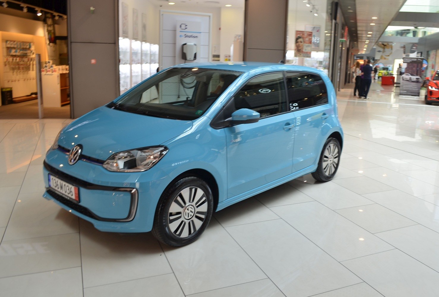 Blue compact electric car with distinctive patterned wheels