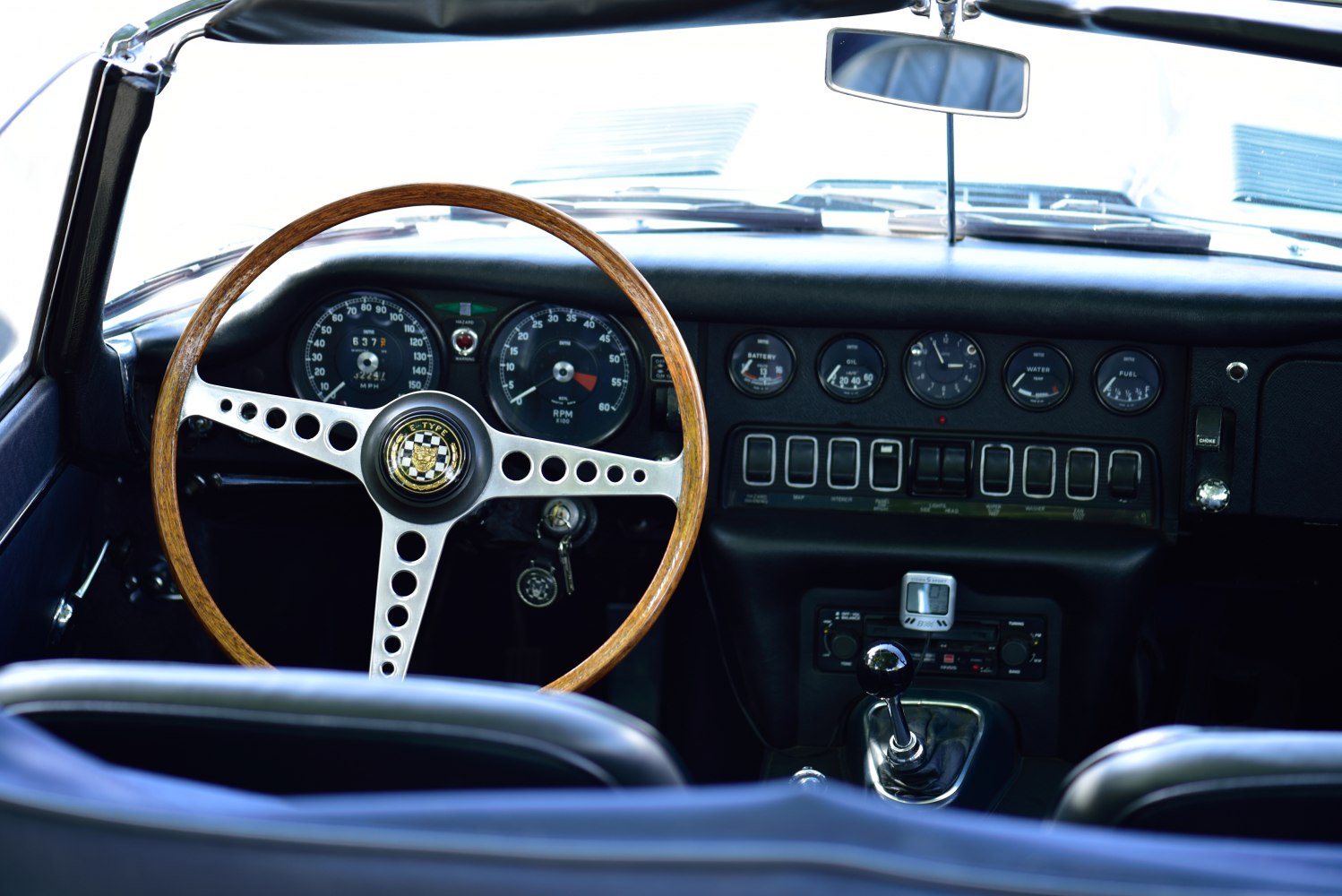 Wooden steering wheel and analog dashboard gauges with manual gear shift