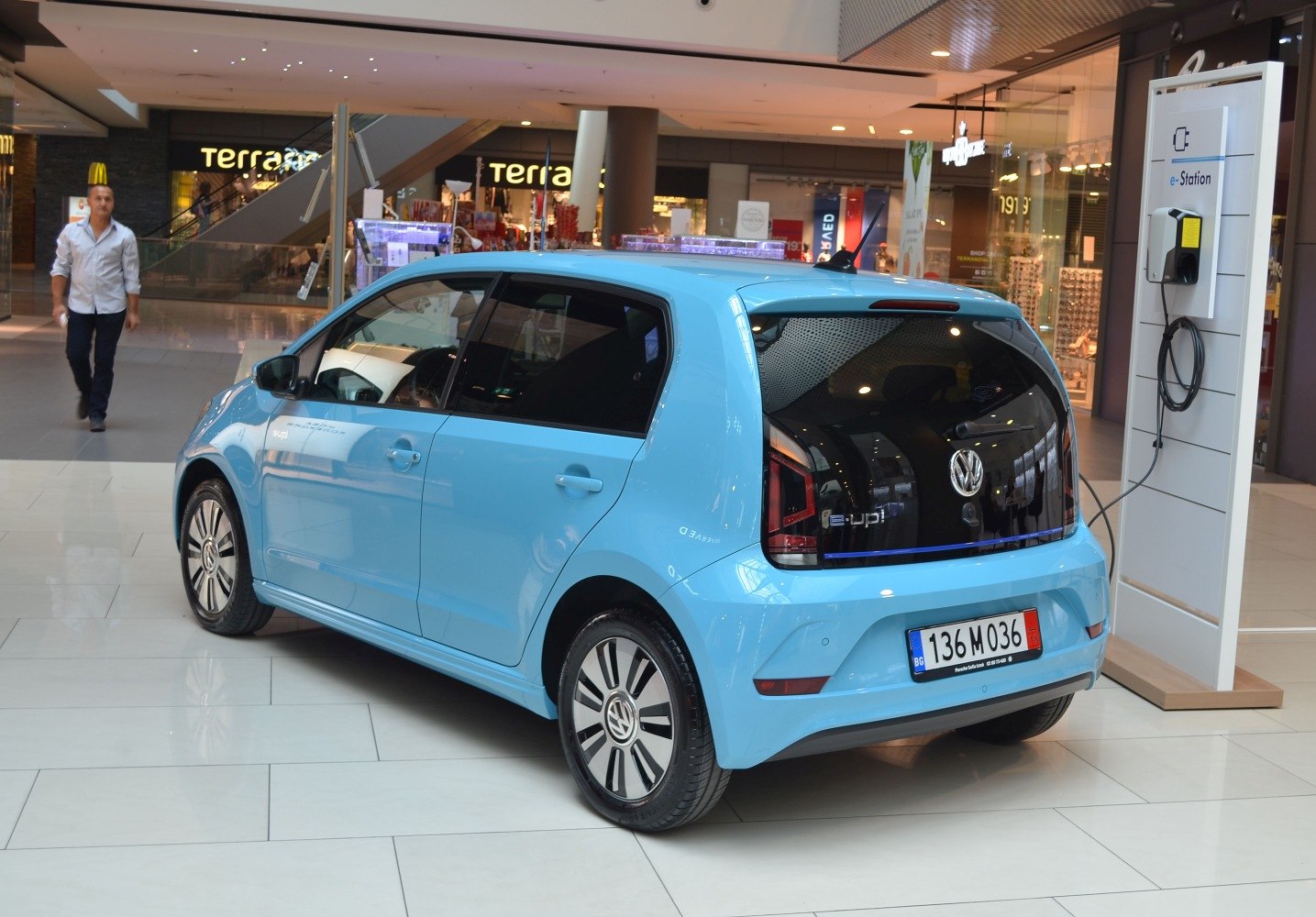 Rear three-quarter view of a small electric hatchback near charging station