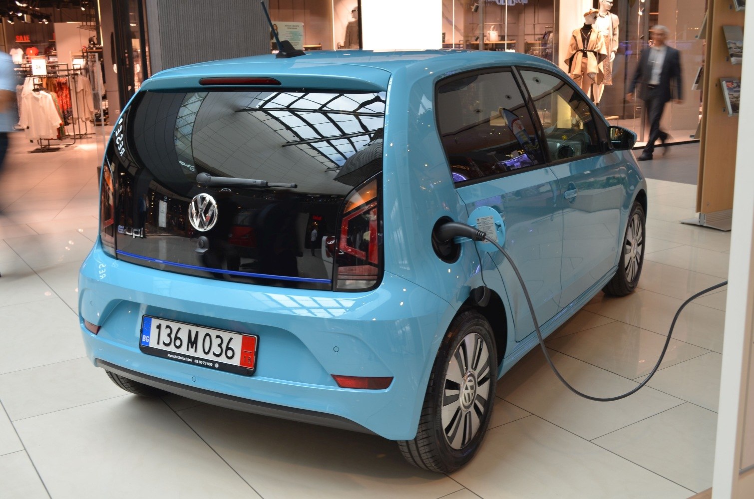 Electric hatchback rear view with charging cable in indoor mall