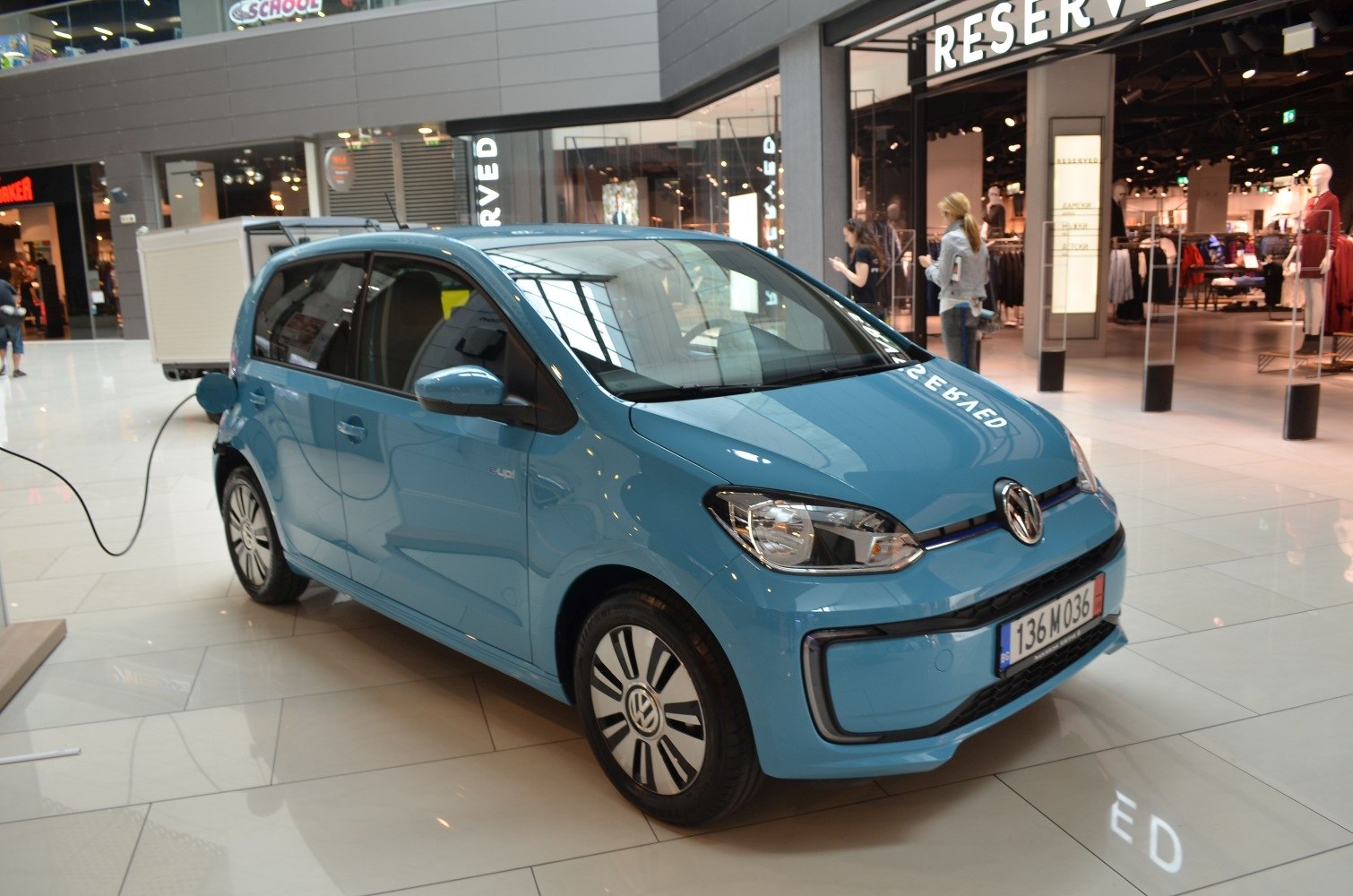 Blue electric hatchback plugged in indoors with compact design