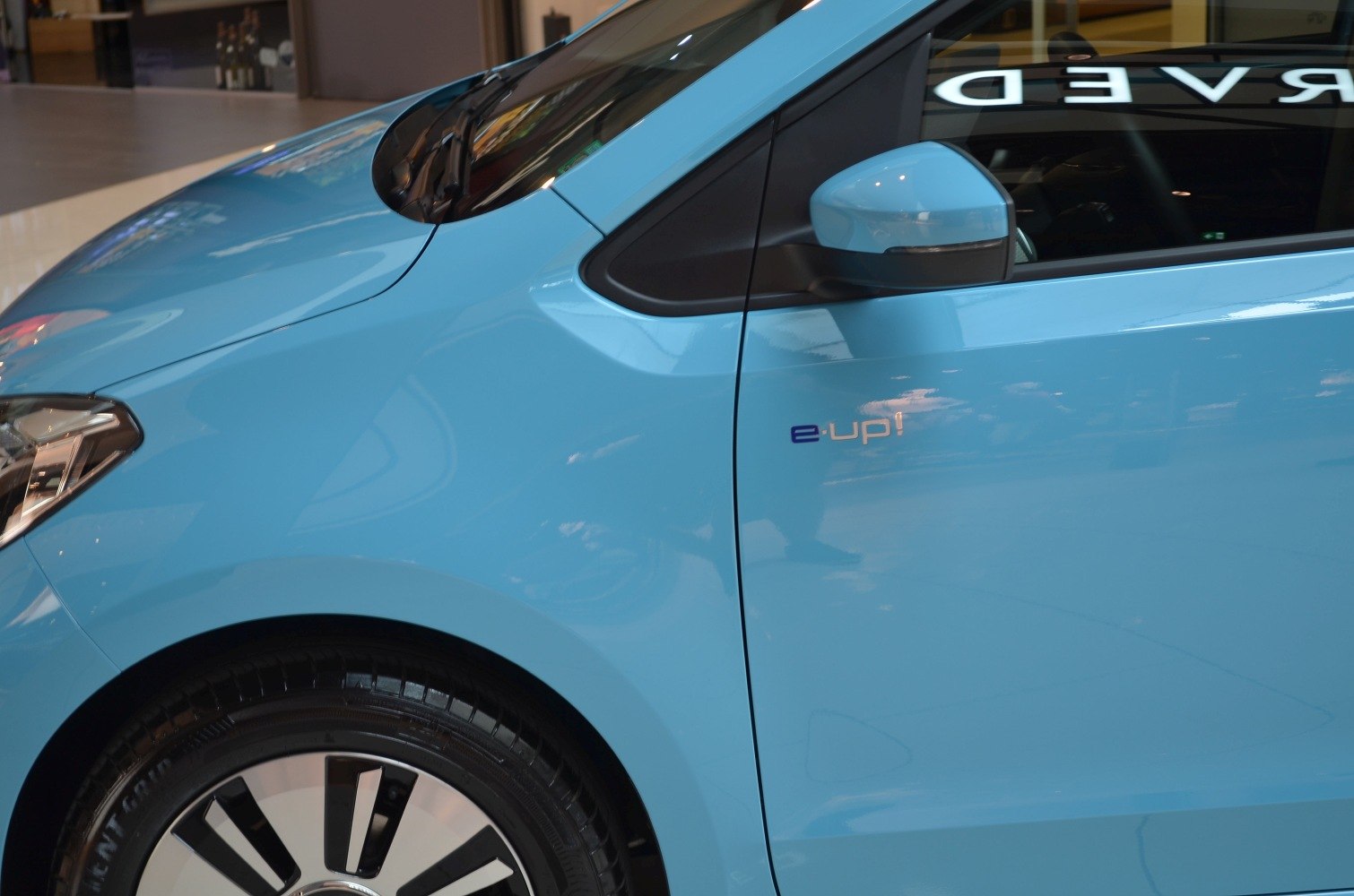 Blue electric compact car front side with unique wheel and e-up badge