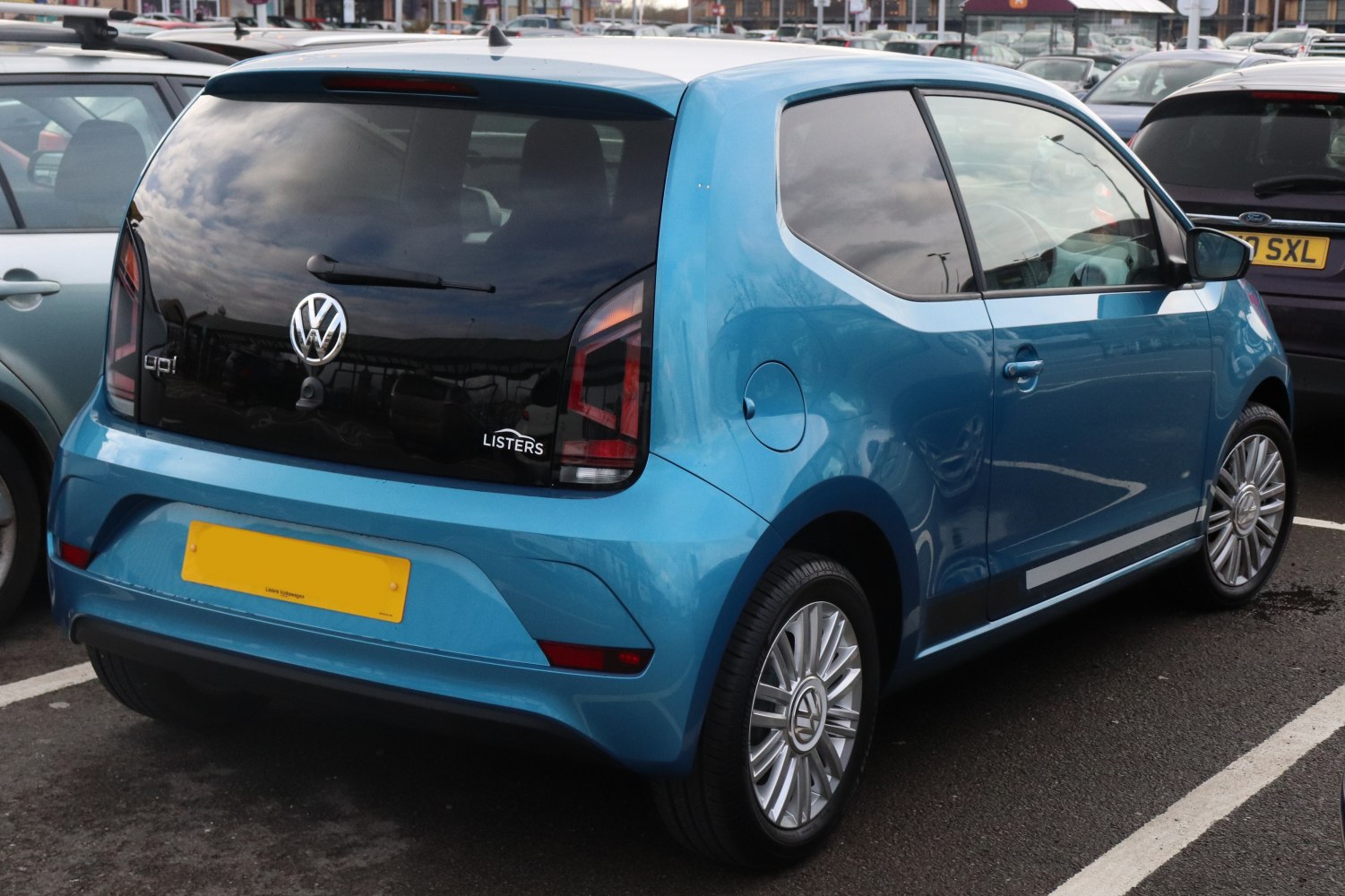 Rear and side view of a blue compact hatchback with unique taillights and alloy wheels