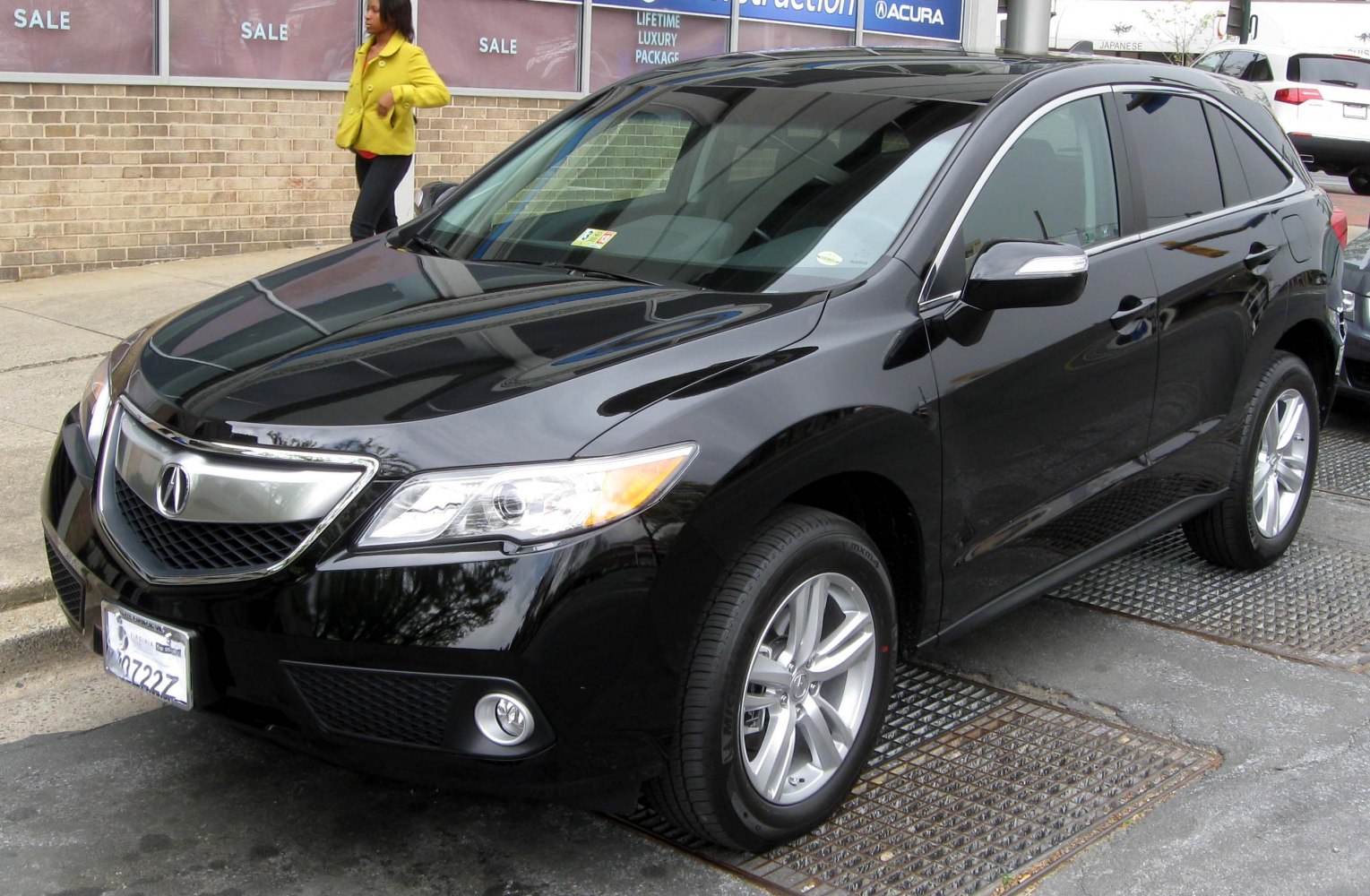 Front side of black SUV with sleek headlights and alloy wheels.
