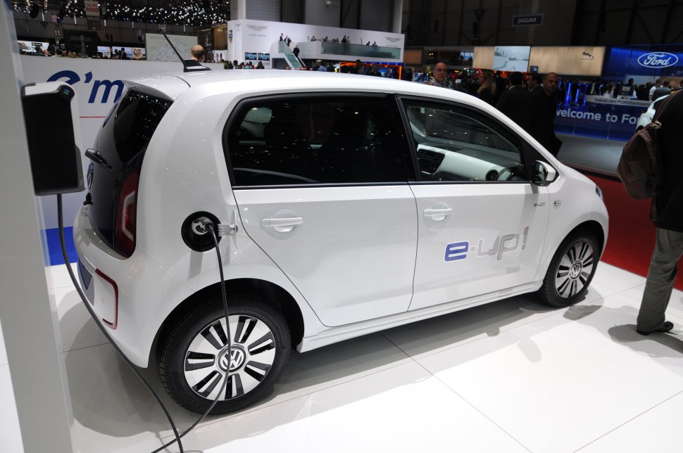 Electric hatchback charging at station, side view, modern compact design