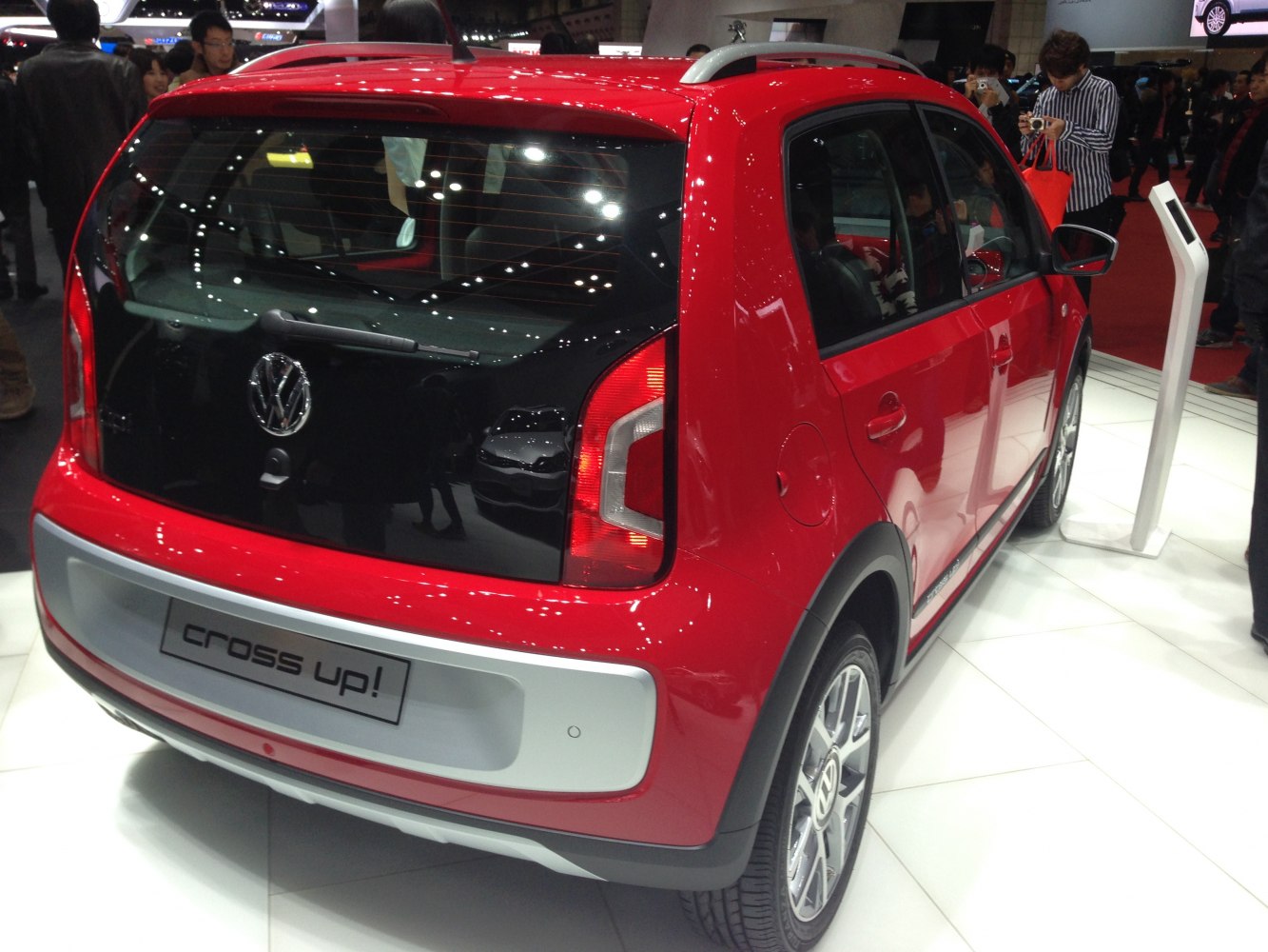 Rear and side view of red hatchback with distinct taillights and black rear window.