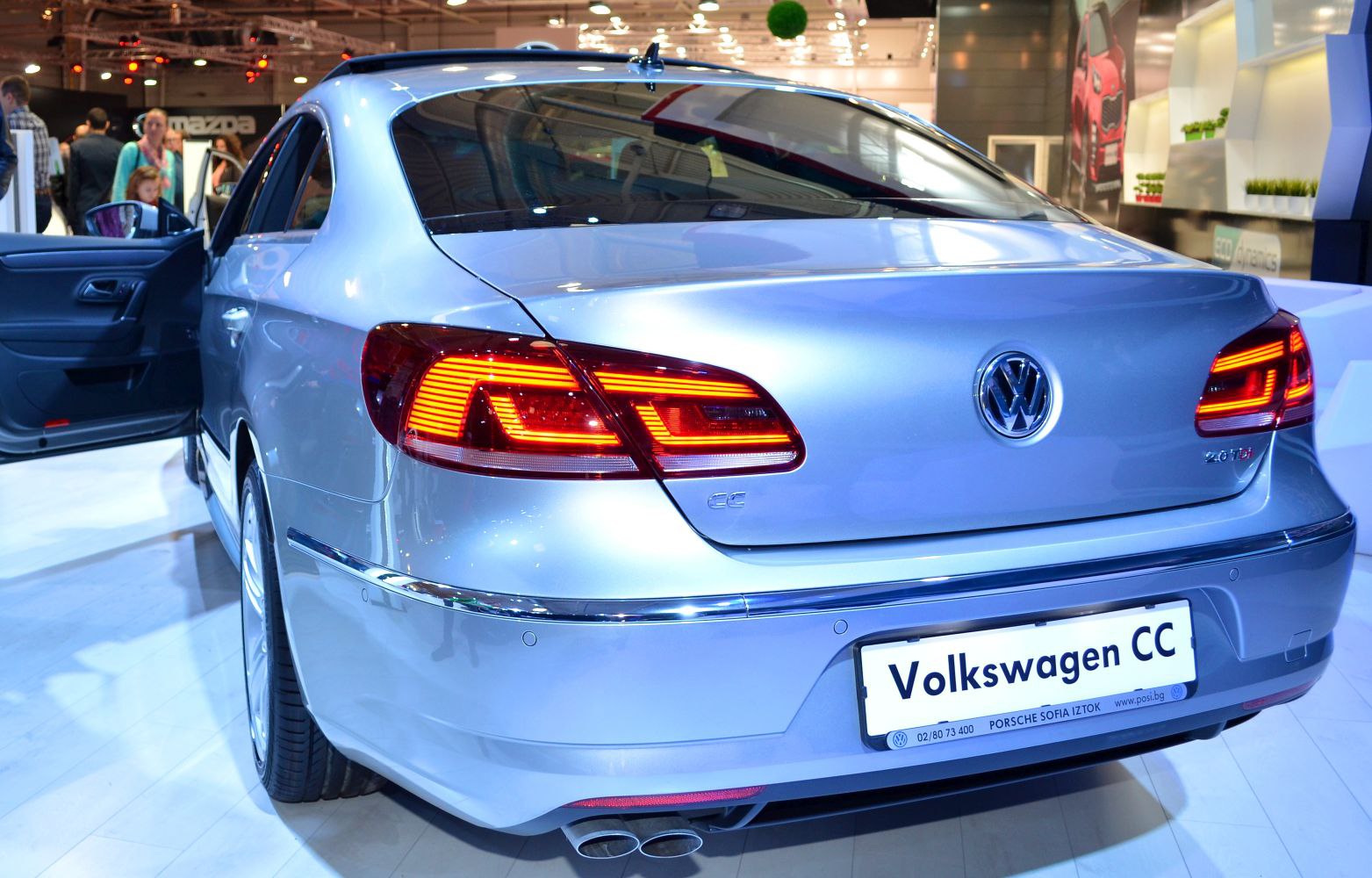 Rear view with illuminated tail lights and dual exhausts of a sedan.