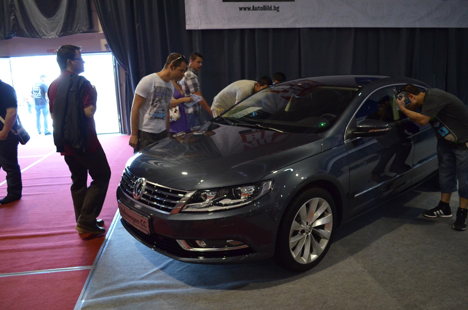 Front grille and headlights of a 2012 facelifted sedan in an indoor auto show.