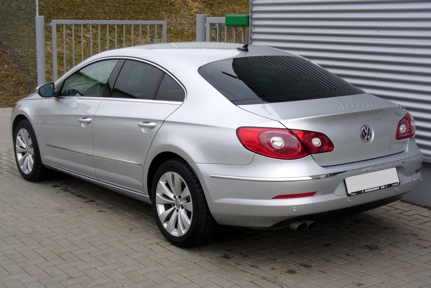 Rear-side profile of a silver mid-size sedan with distinct rear lights and dual exhausts