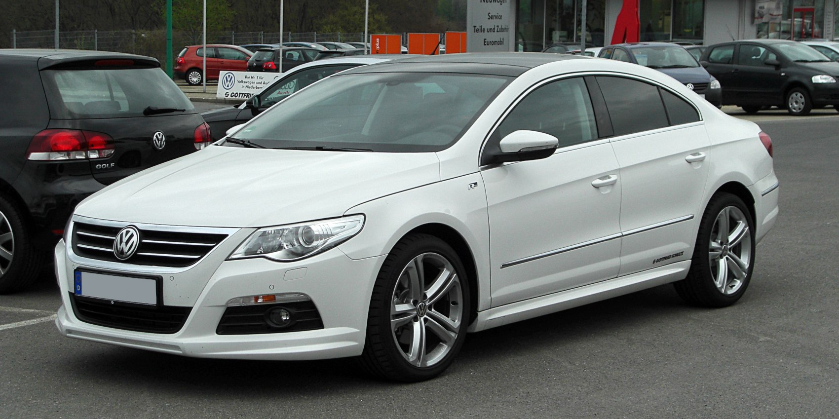 White sporty sedan with chrome grille and alloy wheels front-side view